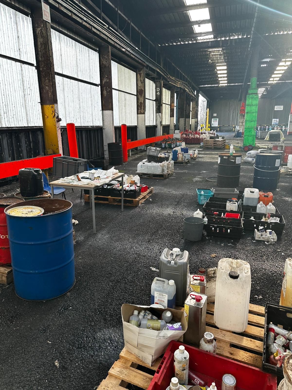 The interior of an industrial unit part-way through a strip-out, with redundant plant and mixed waste awaiting segregation.