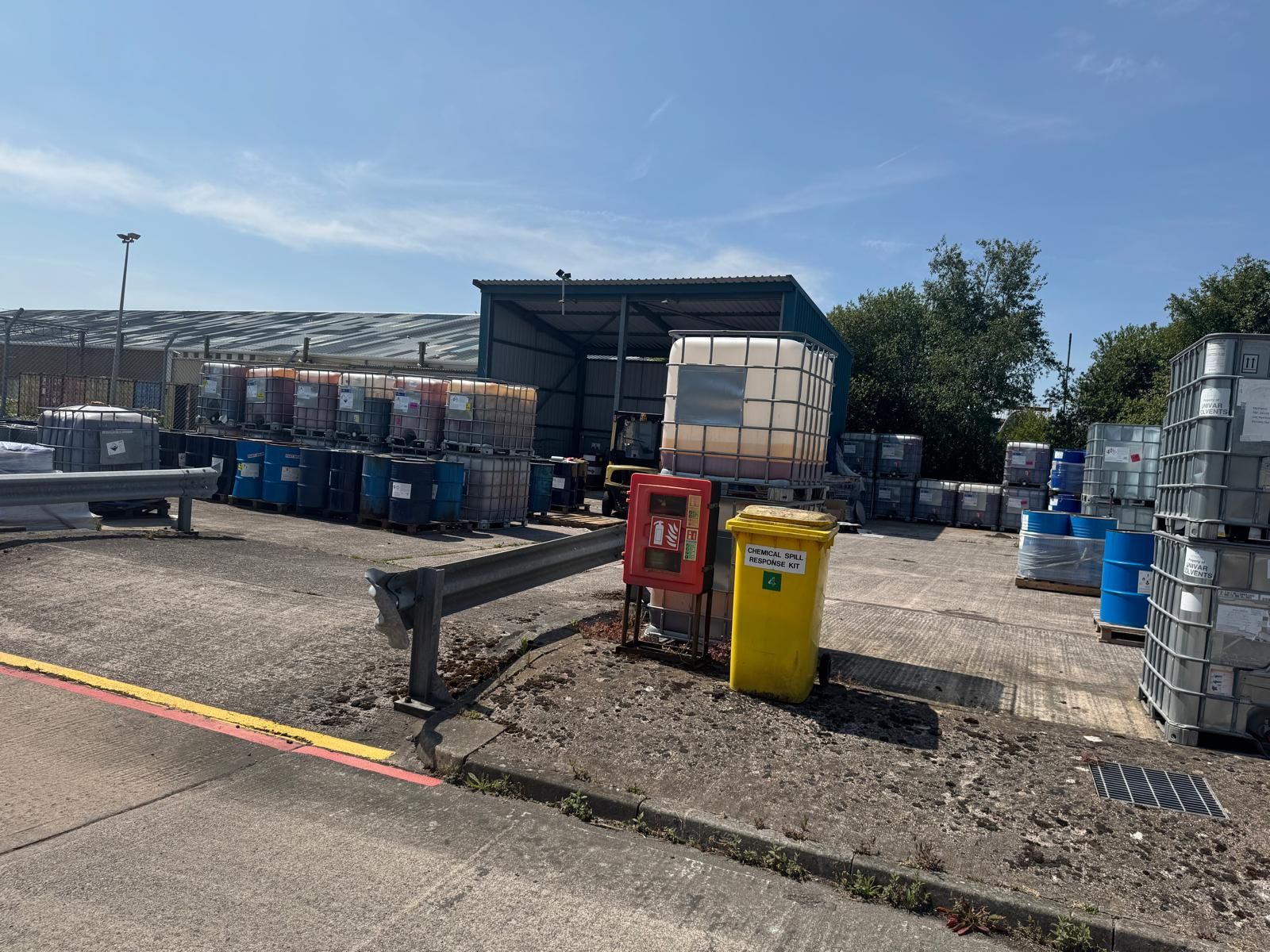 A permitted waste transfer yard with intermediate bulk containers, drums and bins arranged for onward disposal.
