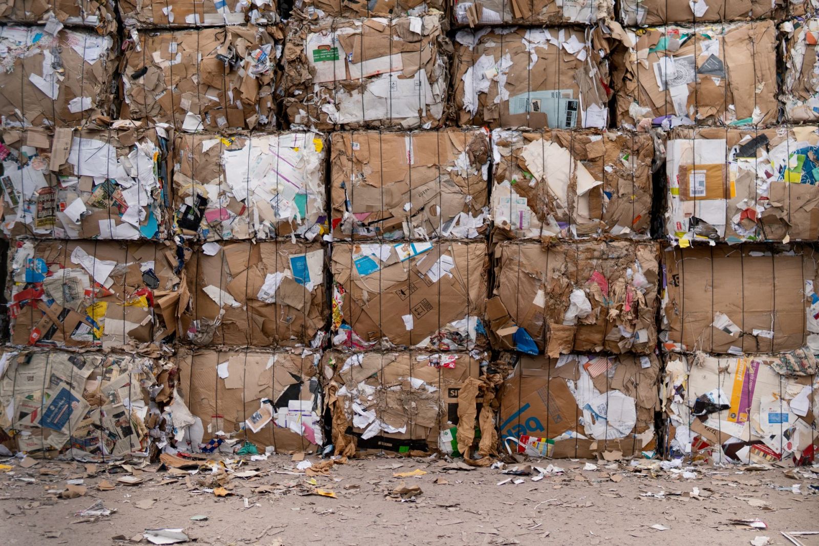 Baled cardboard and paper recyclables stacked in tiers at a permitted waste and recycling facility.